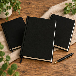 Three plain black canvas notebooks without print on a wood table | Pamusan.com